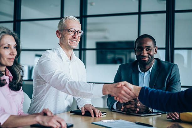 istock Businesspeople shaking hands across the table. 2209979698