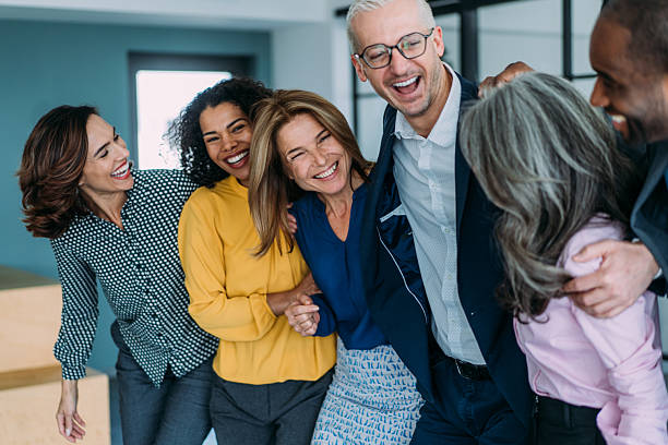 istock Excited coworkers embracing each other during a celebration in the office. 2209979738
