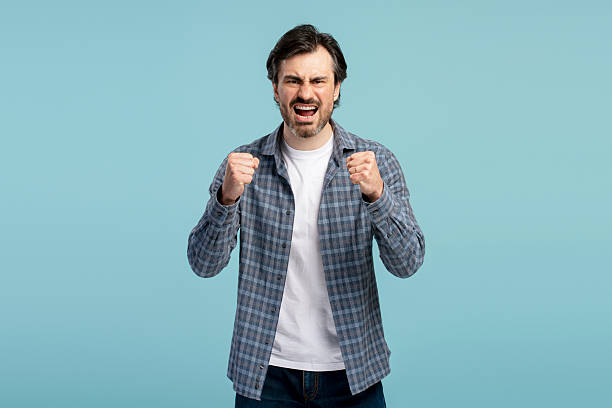 istock Angry man shouting and showing fists on blue background 2209980161