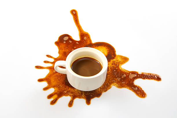 istock A white coffee cup sits on a pristine surface with a rich brown coffee spill spreading outward, creating an artistic pattern. The dark espresso contrasts beautifully with the clean background 2209986590
