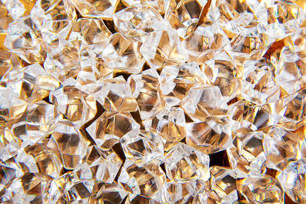 Sparkling clear crystals scattered on a golden surface, reflecting light beautifully, perfect for luxury and elegance-themed designs or festive decorations.