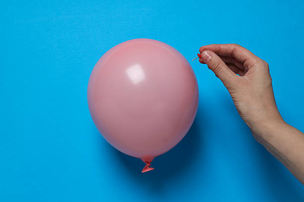 istock Balloon and hand with stationery needle on blue background 2209988462