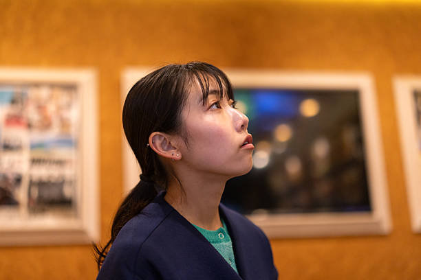 Young woman looking at menu on wall in restaurant