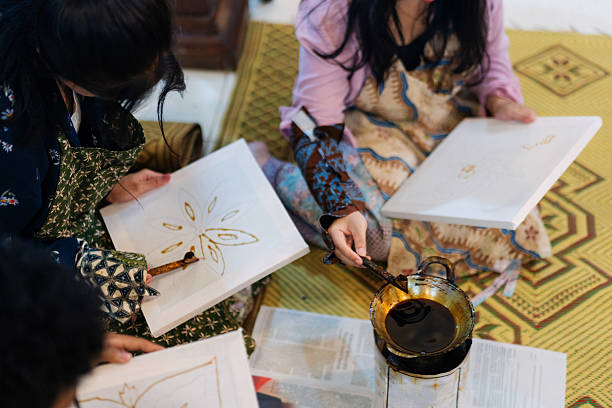 istock Group of Young Adults Hands-On Batik Workshop with Hot Wax and Canting Tools 2210009129