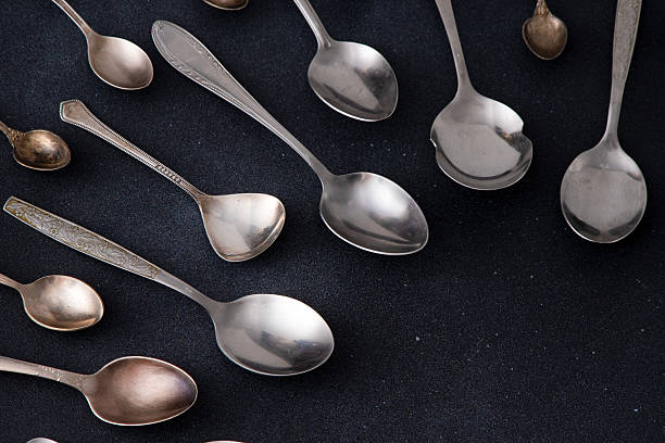 istock Set of different spoons. Silver cutlery on a black background. Spoon on the table 2210011445