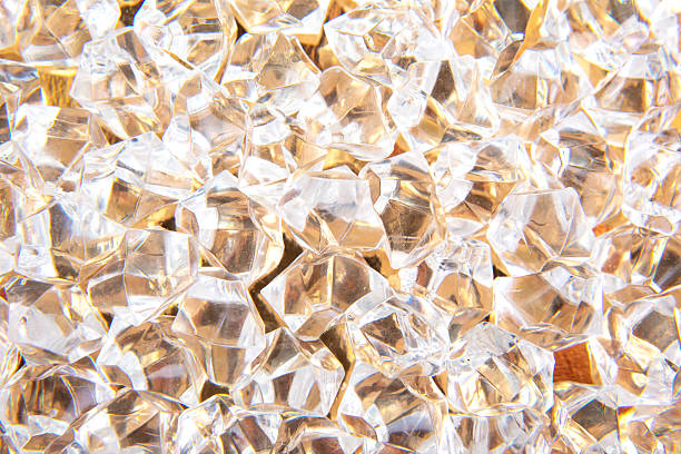 Sparkling clear crystals scattered on a golden surface, reflecting light beautifully, perfect for luxury and elegance-themed designs or festive decorations.