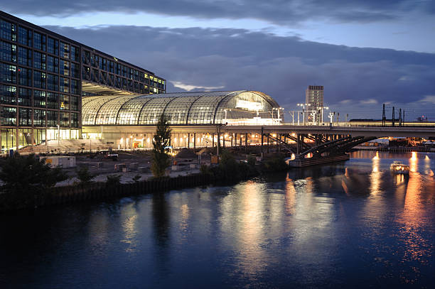 Nighttime Urban Scene with Train, Bridge, and Boat