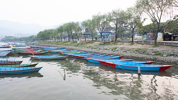Pokhara, Nepal - March 31, 2025: Many traditional boats are docking at Phewa Lake or Phewa Tal in the morning.