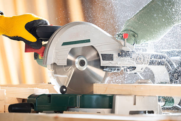 istock Close-up of a carpenter using a circular saw to cut  board 2210013708
