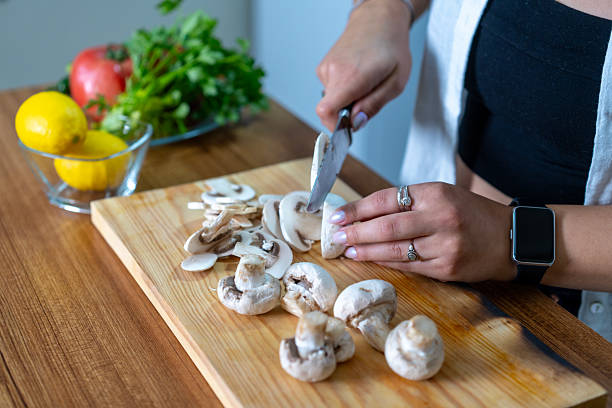 Young woman cutting mushrooms