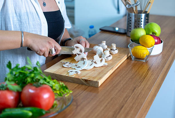 Young woman cutting mushrooms