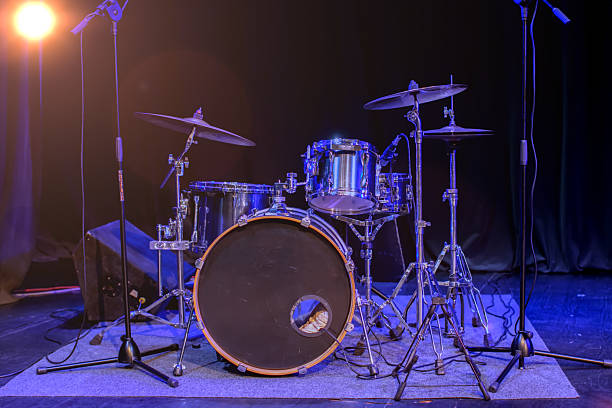 istock On stage there is a drum kit with a microphone illuminated by blue stage lights. 2210016383