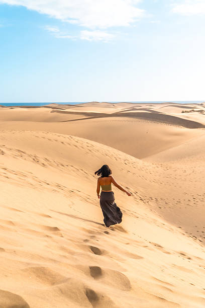 istock Tourist walking on maspalomas dunes in gran canaria, spain 2210018167