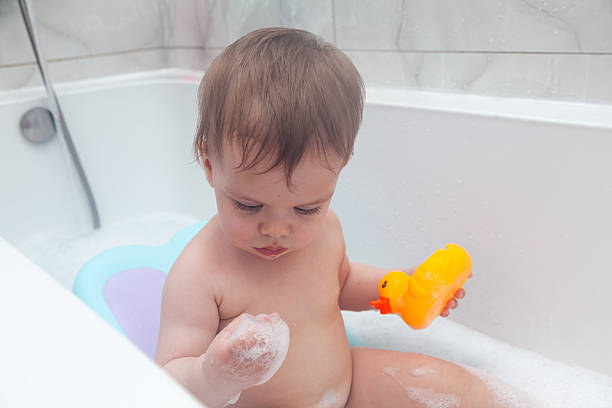 istock Baby taking a bath. Baby washing in a bathtub with ducks. 2210020155