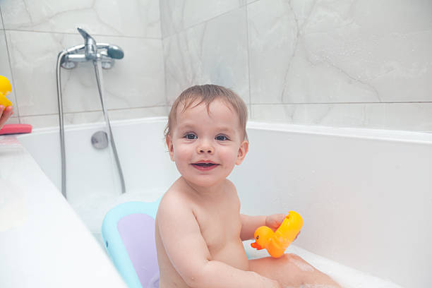 istock Baby taking a bath. Baby washing in a bathtub with ducks. 2210020159