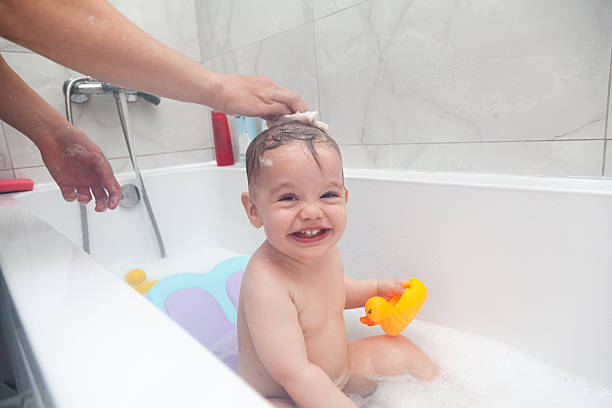 istock Baby taking a bath. Baby washing in a bathtub with ducks. 2210020163