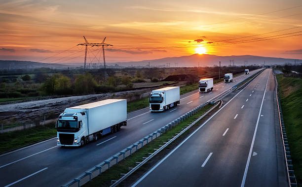 istock Convoy of five white trucks along the highway 2210020983