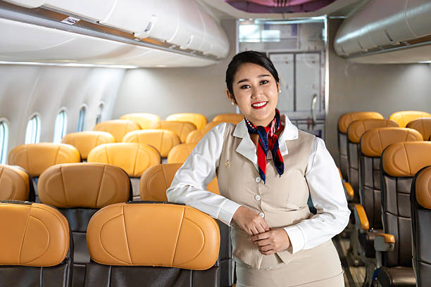 istock Asian flight attendant posing with smile inside aircraft for welcoming passenger on board with seat on the background for airline travel usage 2210022741