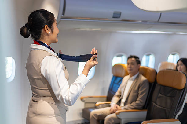 istock Asian flight attendant is demonstrating safety procedure using seat belt before taking off in the airplane for cabin crew and airline business usage 2210022744