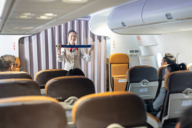 istock Asian flight attendant is demonstrating safety procedure using seat belt before taking off in the airplane for cabin crew and airline business usage 2210022760