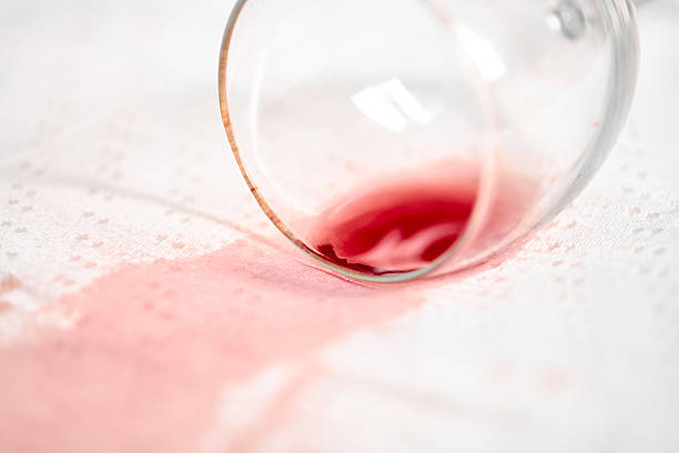 istock Red wine spill on white tablecloth with tipped glass 2210023764