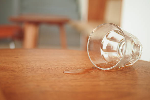 istock A glass has been accidentally spilled on a polished wooden table surface 2210028614