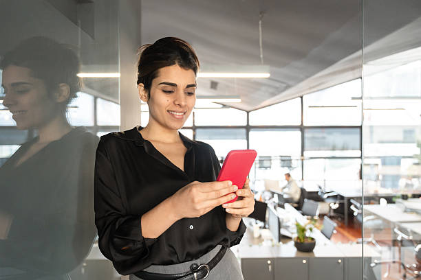 istock Young Indian or arabian business woman ceo manager using cell phone mobile application. Smiling Latin Hispanic businesswoman holding smartphone for finance trading work online in office. Copy space 2210031440