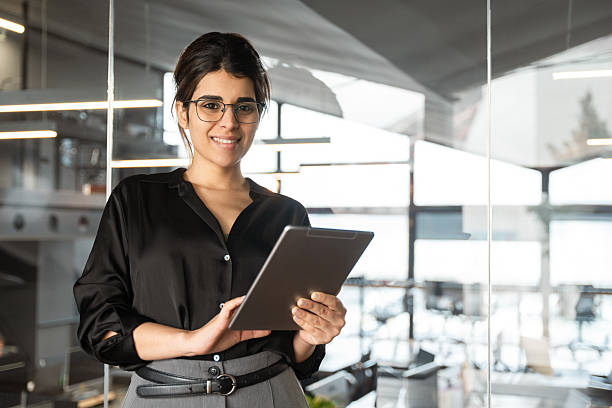 istock Smiling young indian or arabian arab woman ceo manager holding digital computer tab for business, looking at camera. Latin hispanic businesswoman using tablet pc app at work in office. Copy space 2210031445