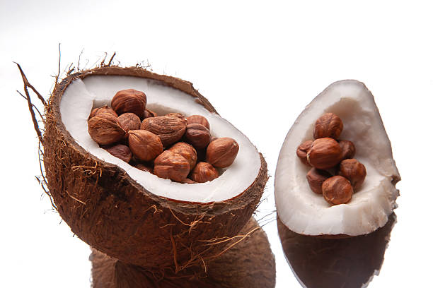 istock A halved coconut filled with whole hazelnuts, showcasing a tropical twist on a white background. Perfect for healthy snack ideas, nut photography, or exotic food concepts 2210031559