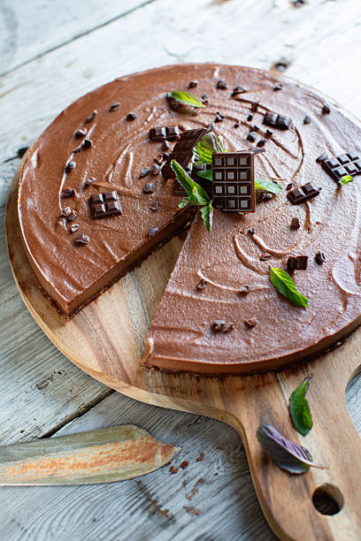 Delicious vegan chocolate dessert cake sliced and served on a rustic board. Rustic background.