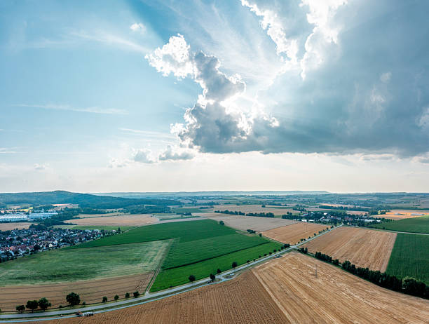 Aerial view panorama image with agricultural fields and the blue cloudy sky at sunset