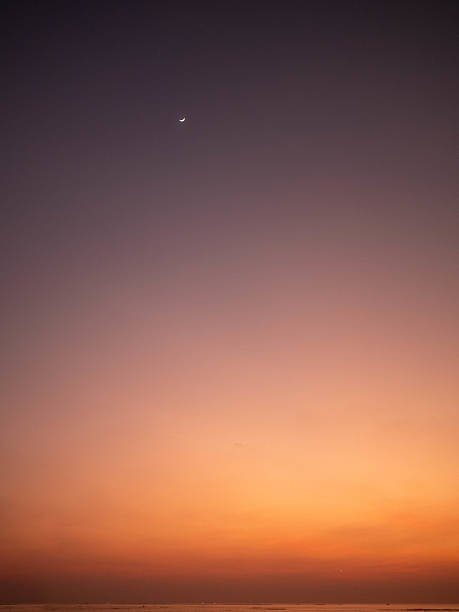 istock Mesmerizing Sunset Sky with Crescent Moon Above Serene Horizon 2210043514