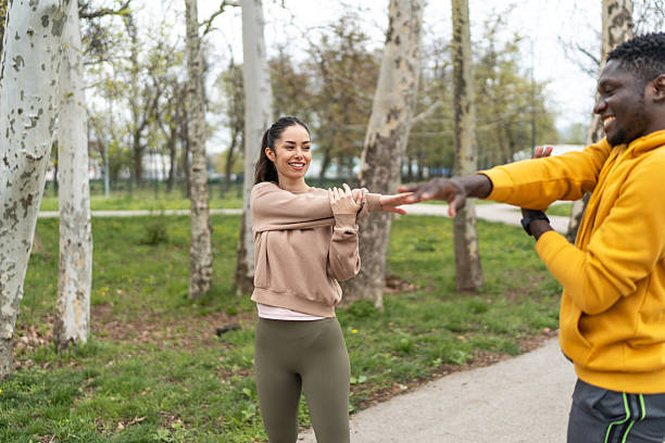 istock Happy active couple stretching arms before workout in park 2210043681
