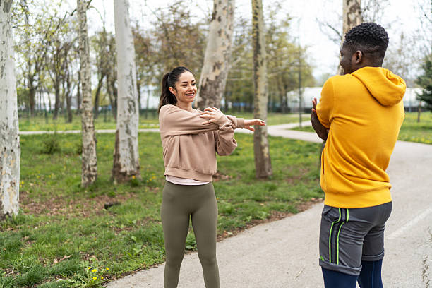 istock Happy active couple stretching arms before workout in park 2210043700