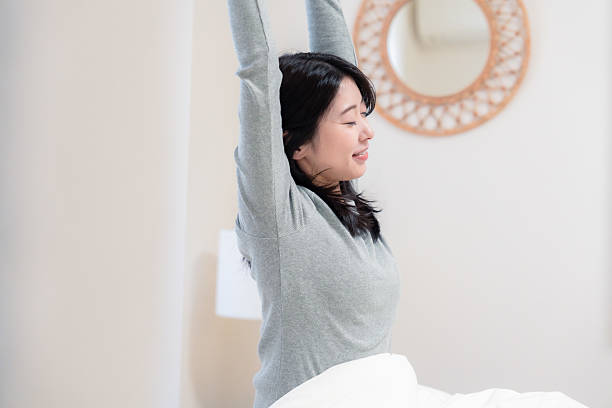 istock Young woman waking up in bed 2210046492
