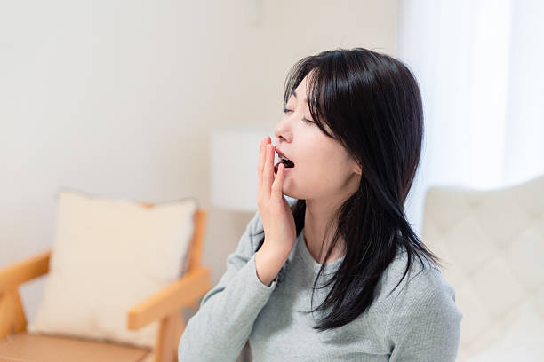 istock Young woman waking up in bed 2210046495