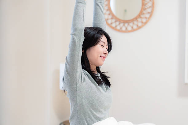 istock Young woman waking up in bed 2210046498