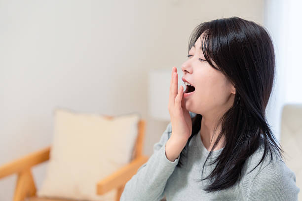 istock Young woman waking up in bed 2210046500