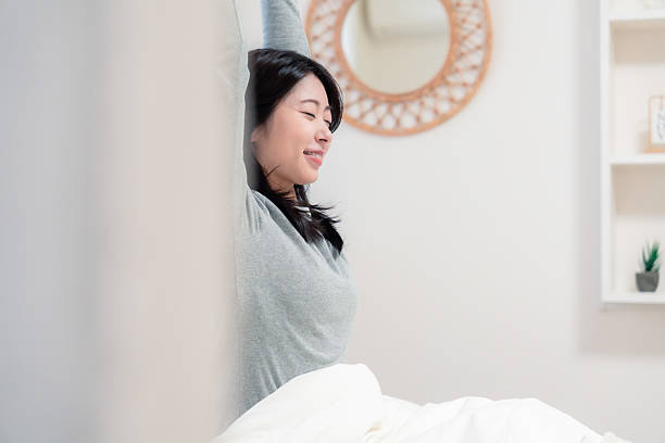 istock Young woman waking up in bed 2210046501