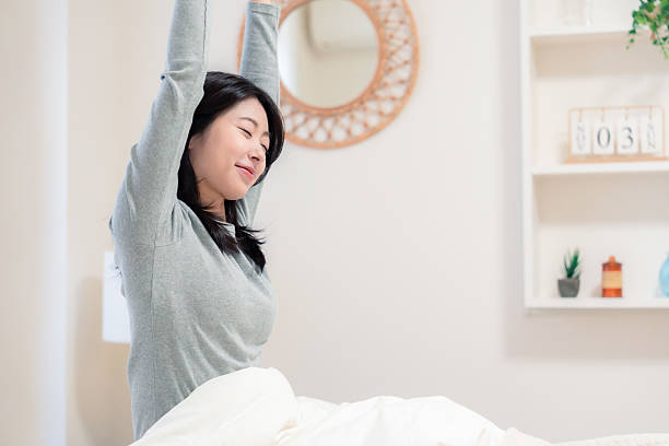Young woman waking up in bed