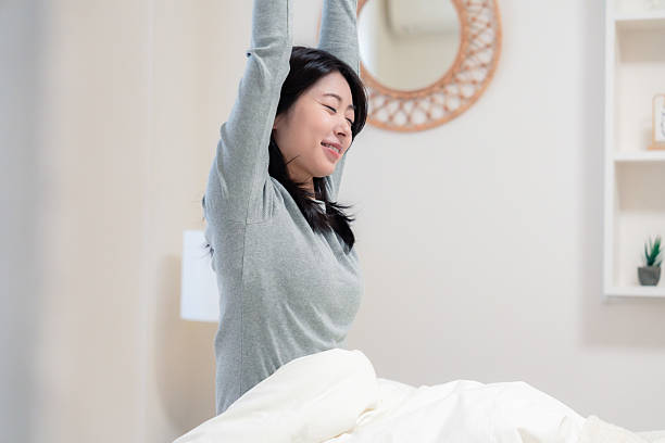 istock Young woman waking up in bed 2210046514