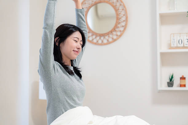 istock Young woman waking up in bed 2210046515