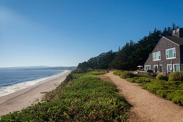 A cliff side home in northern california overlooking the pacific ocean on a sunny day.