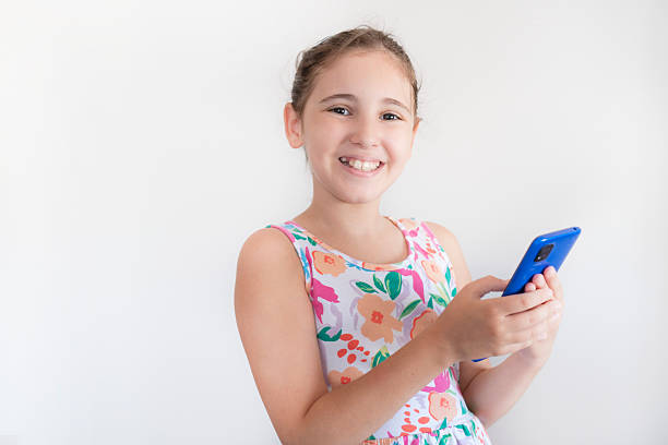istock Happy little girl using smart phone isolated on white background 2210062798