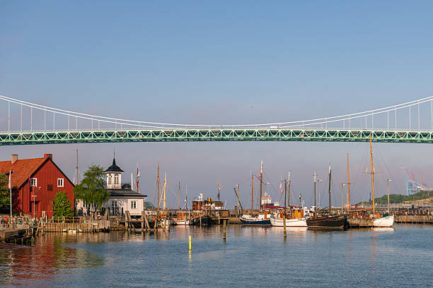 Klippan Marina in Gothenburg, Sweden. Old wooden ships are moored at the jettys. Bridge called Älvsborgsbron in the background