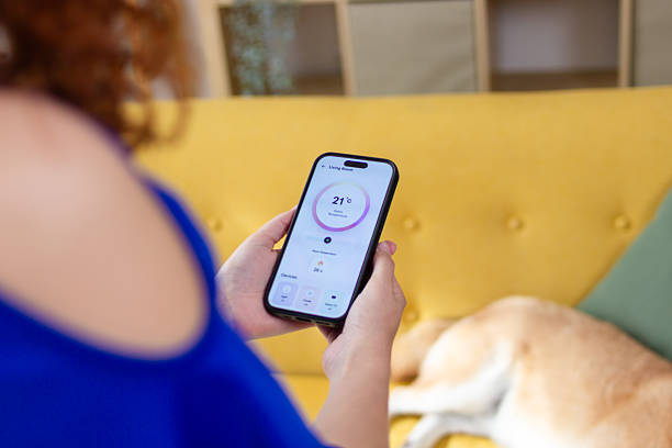 istock Woman using smart home app on mobile phone to control temperature 2210070853