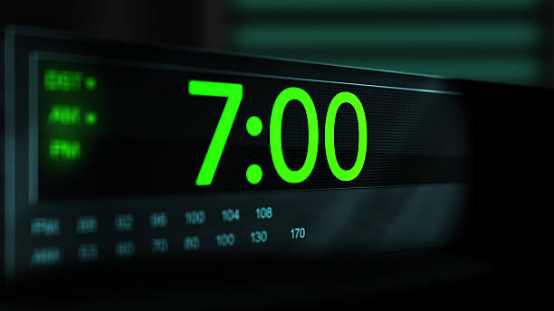 istock Camera pans across old digital clock as time arrives at 7 AM - Green Version 2210075169