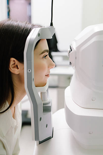 istock Examination of eyes of patient using optical coherence tomograph. Ophthalmologist is scanning cornea of girl patient. Optical coherence tomography OCT scan to create pictures of the back of eye. 2210075444