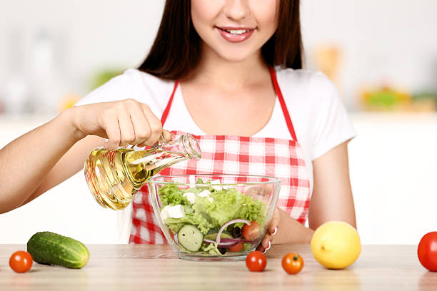 istock Beautiful woman cooking salad in the kitchen 2210075452