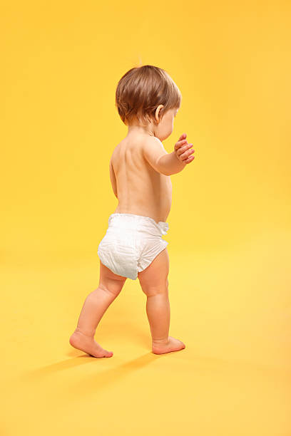 istock Little child in diaper on orange background 2210080253